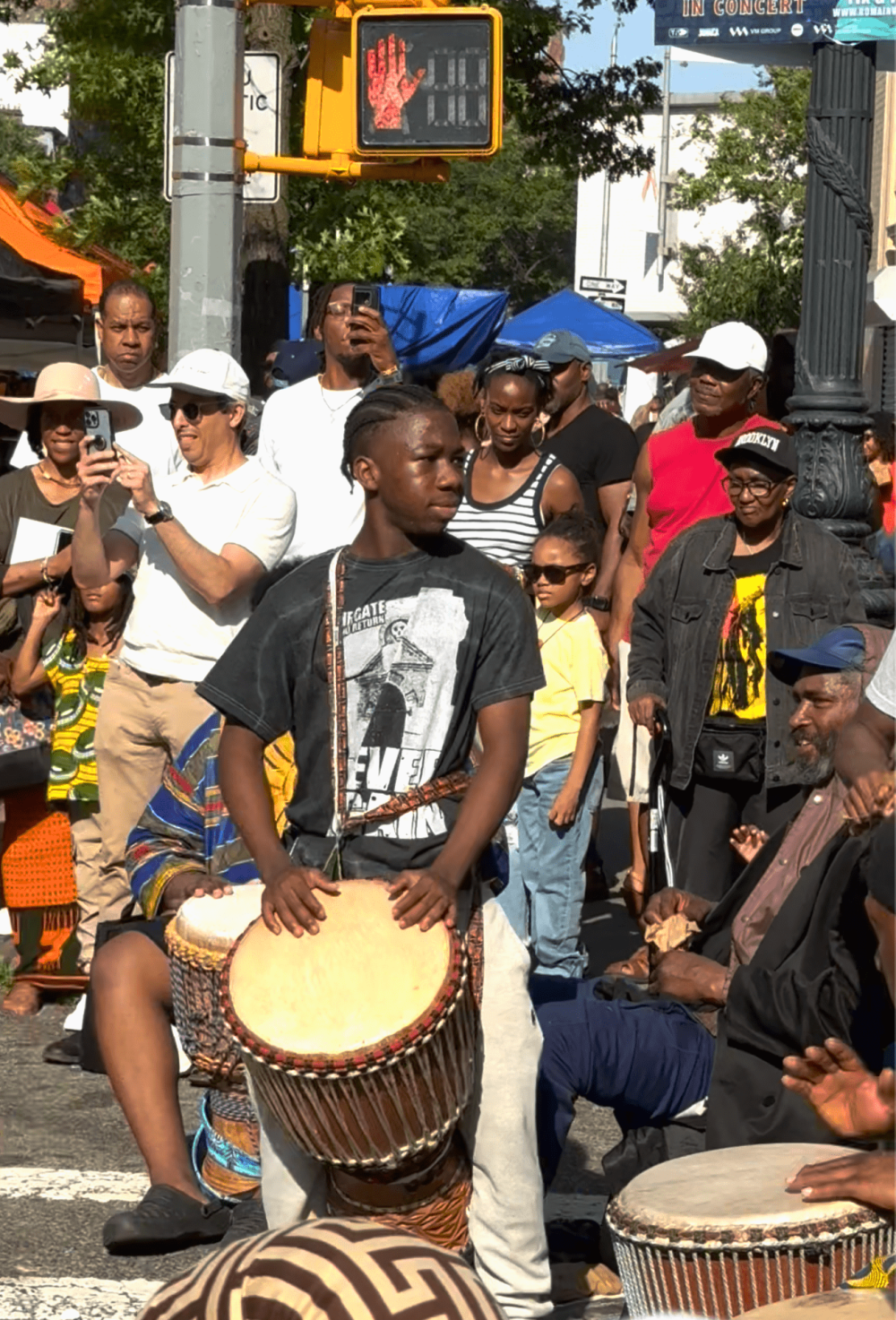 Young man passionately plays a djembe drum.