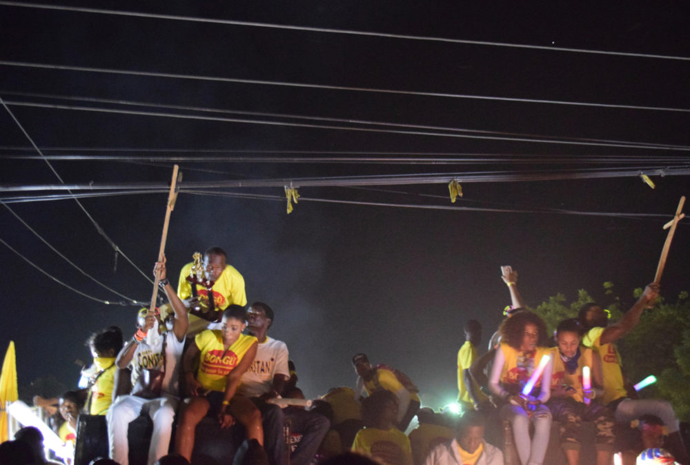 As the float makes its way back to its parking spot, we have to duck under low power lines. People are stationed with poles at each corner of the float to hold the lines up.