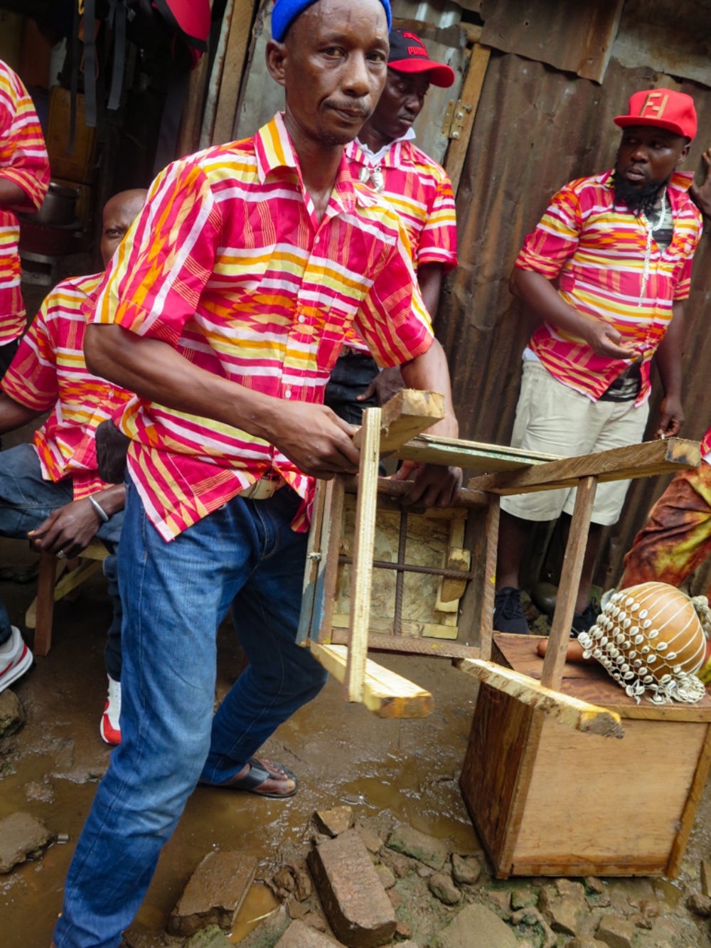 Member of Dr. Oloh's Milo Jazz Band, displaying seated gumbe drum