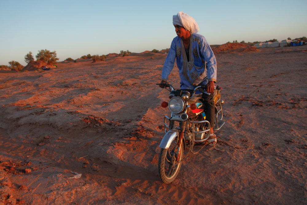 A young M'hamid local rides a motorcycle through the festival grounds.