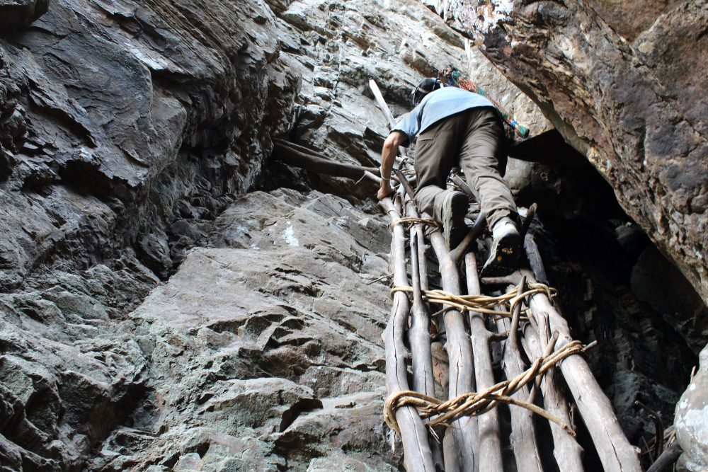 Sylvain climbing the traditional stairs near Doucki.  Photo by Naby Camara