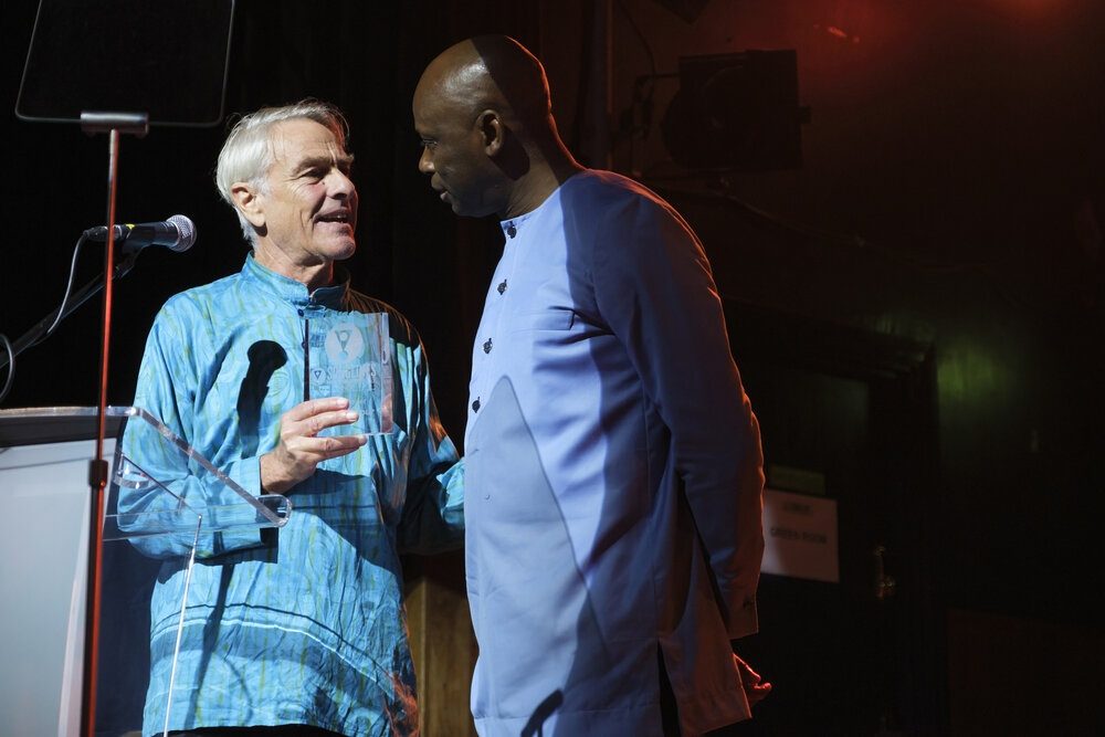 Simon Broughton, Songlines editor in chief (L.), with Youssou N'Dour's manager Dudu Sarr (R.) accepting the award on his behalf.